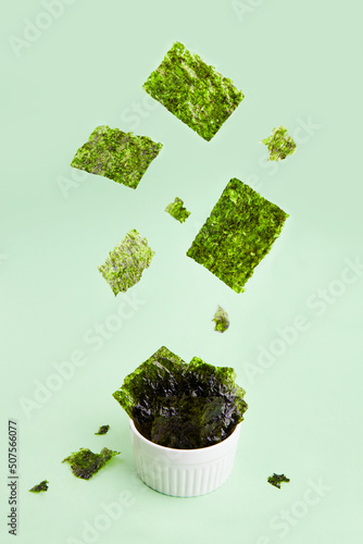 Flying crispy nori seaweed. Healthy snack. Traditional Japanese dry seaweed sheets. Creative concept, levitation.