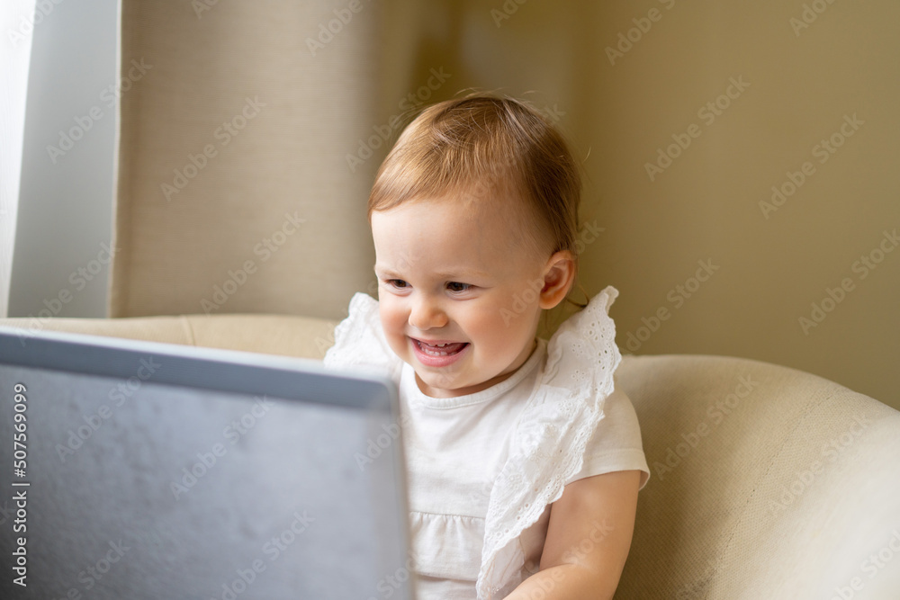 The child sits at a laptop and communicates with his grandmother on the Internet The child sits at a laptop and communicates with his grandmother on the Internet