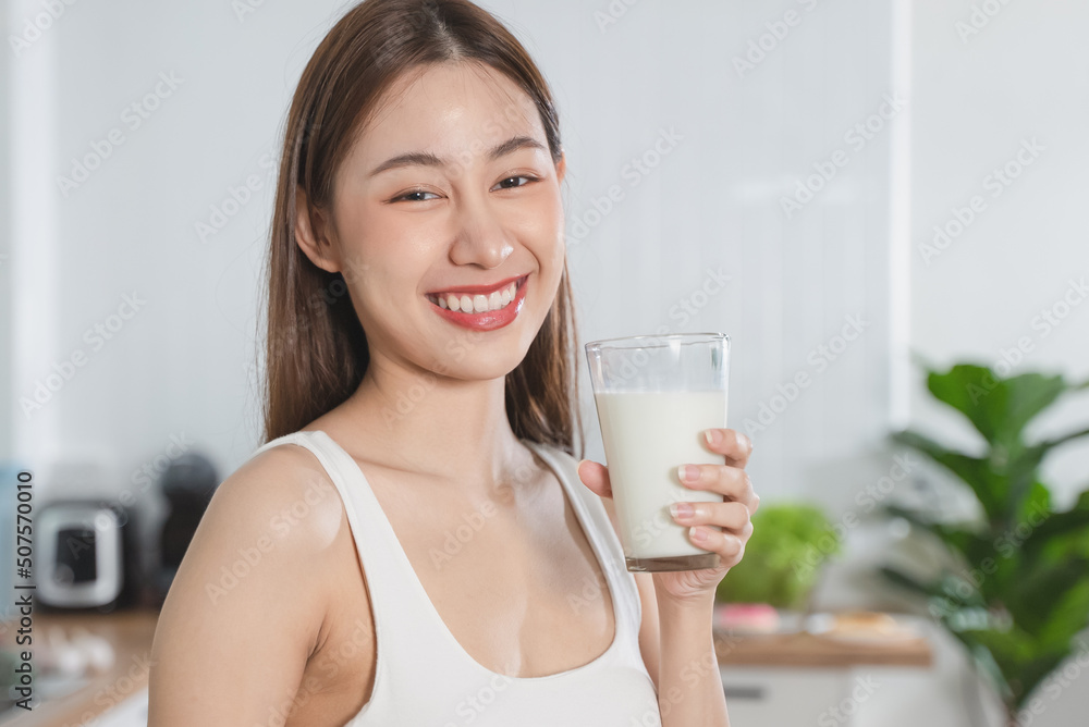 Woman smiling and holding a glass of mineral water Woman smiling and holding a glass of mineral water