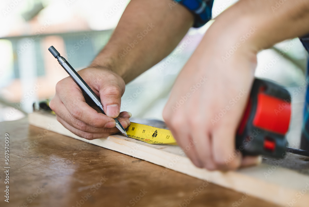 Hands of person doing diy project at home. Man measuring wood to doing cabinet craftworks as a hobby. Hands of person doing diy project at home. Man measuring wood to doing cabinet craftworks as a hobby.