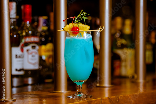 Glass of Blue Hawaii Cocktail on Wooden Bar Counter