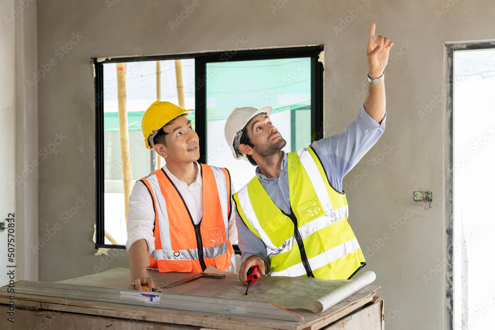 Two civil engineers man inspecting construction of house in village that they responsible for outdoors for construction of residential houses to be in accordance with standards and strong Two civil engineers man inspecting construction of house in village that they responsible for outdoors for construction of residential houses to be in accordance with standards and strong
