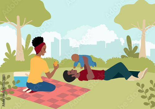 Happy black family playing with their baby in the city park