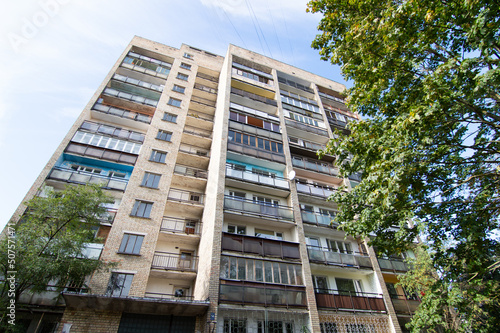 Murais de parede Many storied soviet time building with balconies surrounded by trees