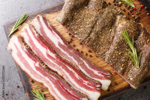 Fotografie Stripy cured pork side bacon pancetta smoked on wood chip closeup on the wooden board on the table