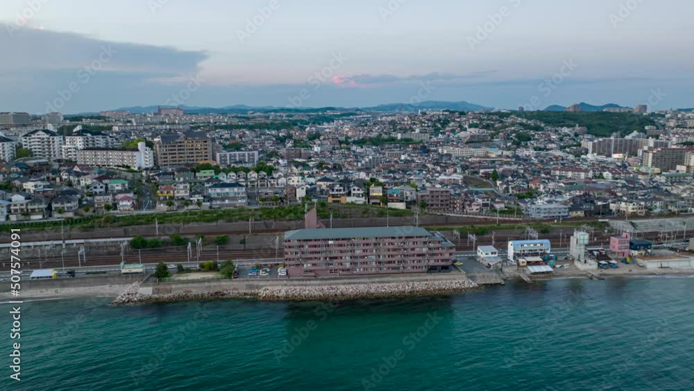 Hyperlapse of trains moving by sprawling condos on coast at blue hour Hyperlapse of trains moving by sprawling condos on coast at blue hour