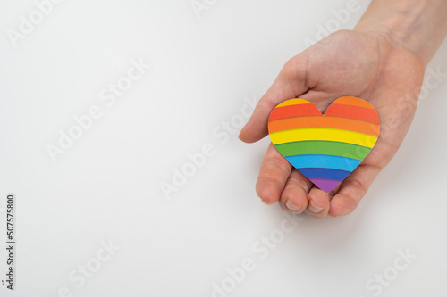 Female hands with rainbow paper heart isolated on white background. Copy space. 