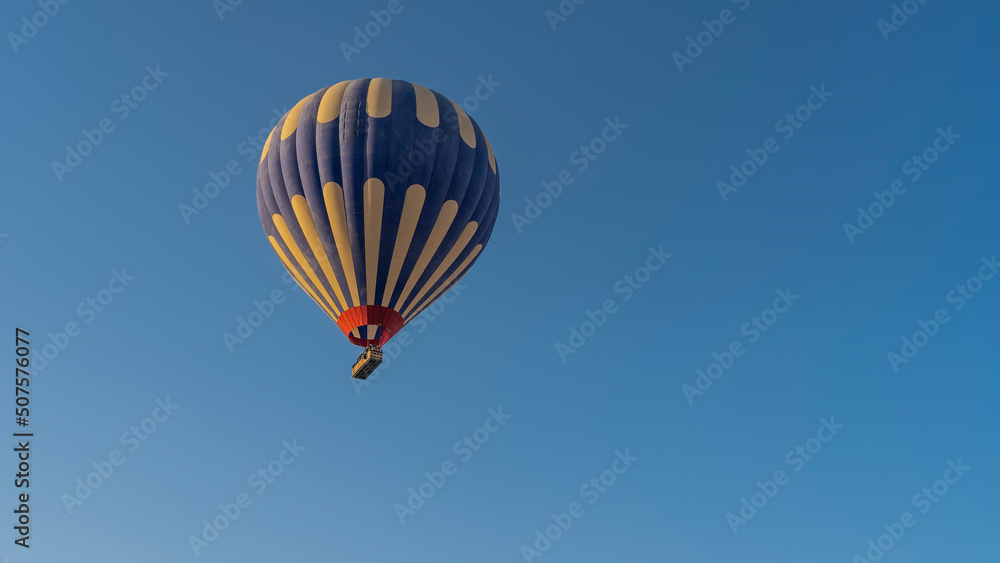 A bright blue-yellow balloon in a clear azure sky. Close-up. Copy Space A bright blue-yellow balloon in a clear azure sky. Close-up. Copy Space