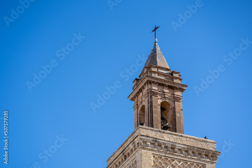 The stone tower of the church in the old town of Spain is a cross with a blue sky