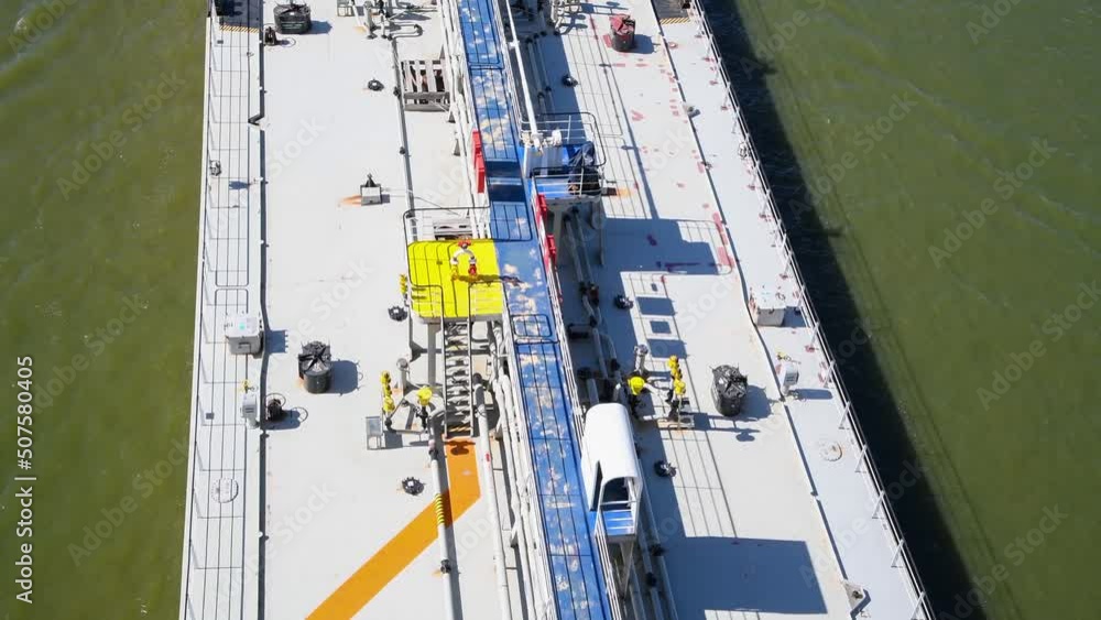 Close-up aerial view of grey deck of large Chemical/Oil Products Tanker sailing on green river water in a sunny day. 4K resolution real time video. Shipping theme. Close-up aerial view of grey deck of large Chemical/Oil Products Tanker sailing on green river water in a sunny day. 4K resolution real time video. Shipping theme.