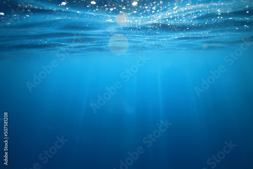 ocean underwater rays of light background, under blue water sunlight