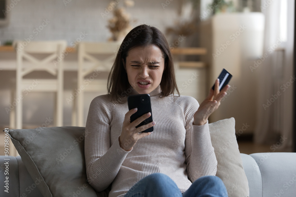 Nervous confused bank customer woman facing problems with online international payments, transactions, blocked credit card, using internet app, holding smartphone, staring at screen with worry Nervous confused bank customer woman facing problems with online international payments, transactions, blocked credit card, using internet app, holding smartphone, staring at screen with worry