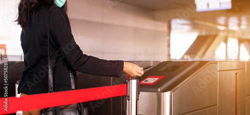 Woman passenger tapping card to automatic doors entrance at train station,Transportation concept