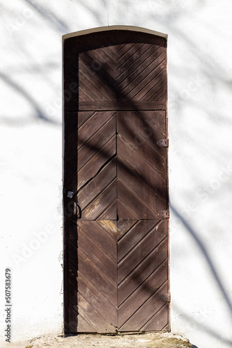 Antique wooden brown door against a white wall. Oginsky Palace, Smorgon district, Belarus photo