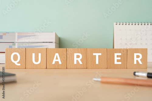 4分の1・クオーターのイメージ｜「QUARTER」と書かれた積み木が置かれたデスク photo