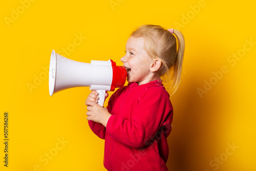 child screaming megaphone looks up on bright yellow background