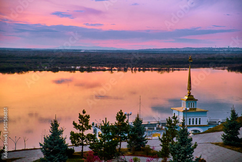 The territory of the tourist complex Zaimka against the background of a bright sunset over the Ussuri River near the city of Khabarovsk. Russia. photo