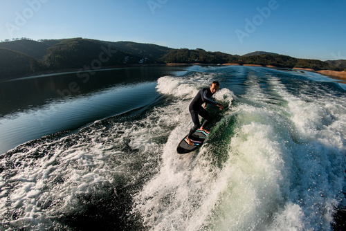 beautiful view of man masterfully riding with wakesurf board on a wave