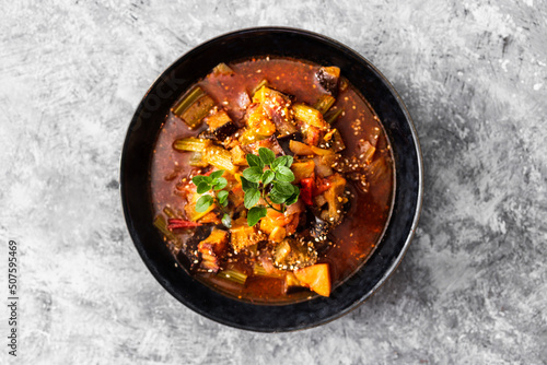 healthy plant-based food, vegan turkish güveç hot pot with eggplant celeri and potaotes in spicy broth with mixed herbs