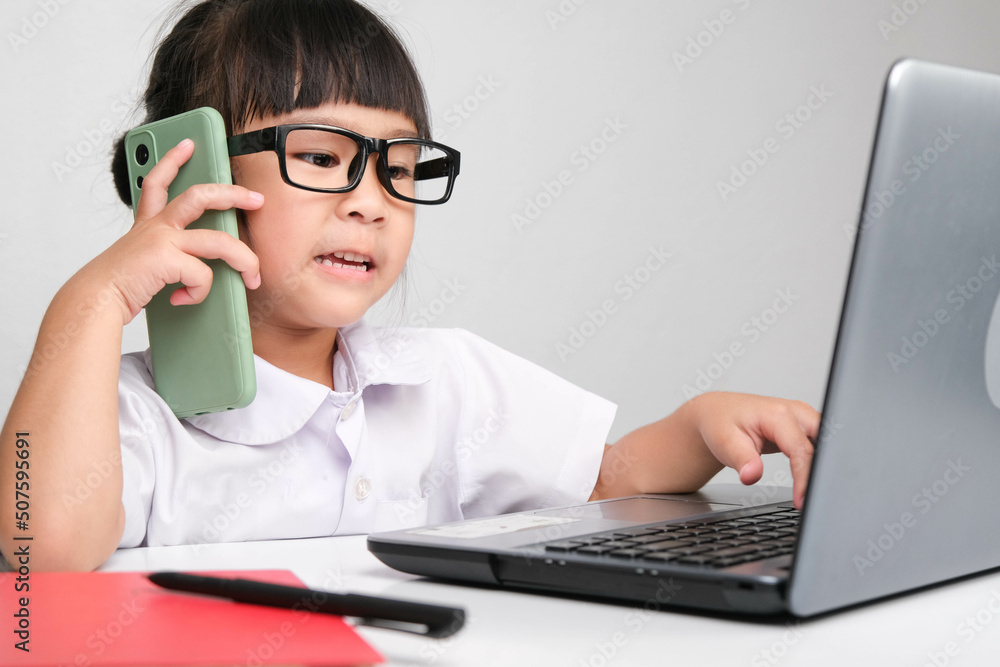 Little business woman with laptop working in office while talking on the phone Children and business concepts Little business woman with laptop working in office while talking on the phone Children and business concepts
