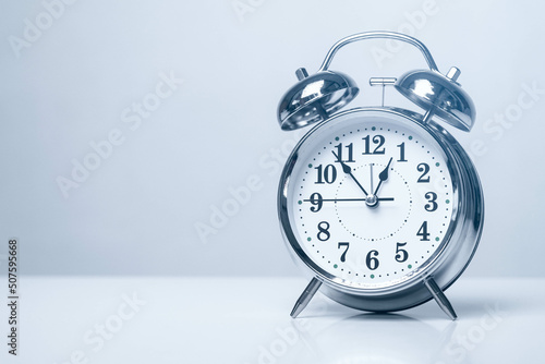 Vintage alarm clock isolated on white background. 12 o'clock reminder. Time concept