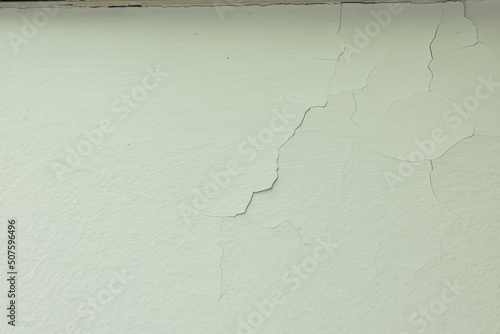 Crack in the paint on the wall in a house or apartment. Cracked paint due to moisture and poor adhesion on the wall.