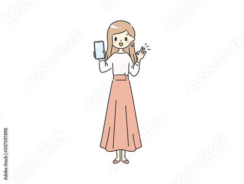 スマホを持ってOKポーズをするスカート女性【ピンク】【全身】