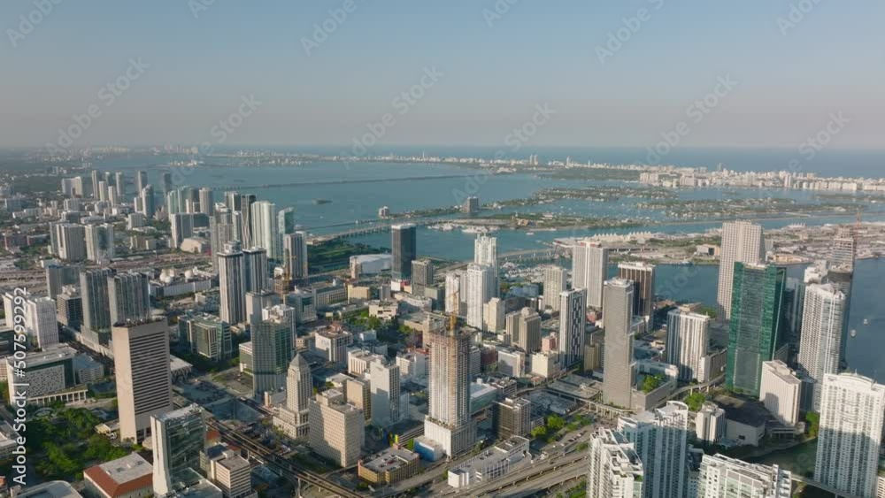 Cinematic shot of high rise downtown apartment buildings. Sea bay with island in background. Miami, USA Cinematic shot of high rise downtown apartment buildings. Sea bay with island in background. Miami, USA