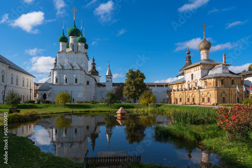 View of the Church of St. John the Theologian and the Church of the Hodegetria on the right against the background of the pond in Vladychy Dvor, Rostov Kremlin, Rostov Veliky, Yaroslavl region, Russia