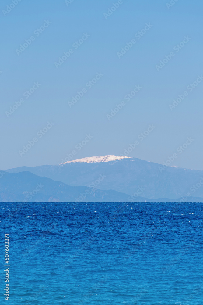 Seascape of the ocean in Rhodes Greece showing in the background a mountain top with snow