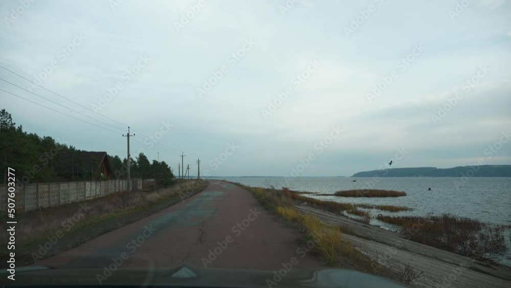 Windshield View Driving Car Along Dam on Dnieper River Reservoir Ukraine Europe. Overcast Cloudy Sky. Autumn Winter Season. 2x Slow motion 60 fps 4K Windshield View Driving Car Along Dam on Dnieper River Reservoir Ukraine Europe. Overcast Cloudy Sky. Autumn Winter Season. 2x Slow motion 60 fps 4K