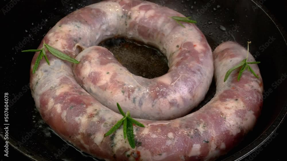 Frying delicious pork sausages circles roasted in frying pan in boiled cooking oil with rosemary. Frying delicious pork sausages circles roasted in frying pan in boiled cooking oil with rosemary.