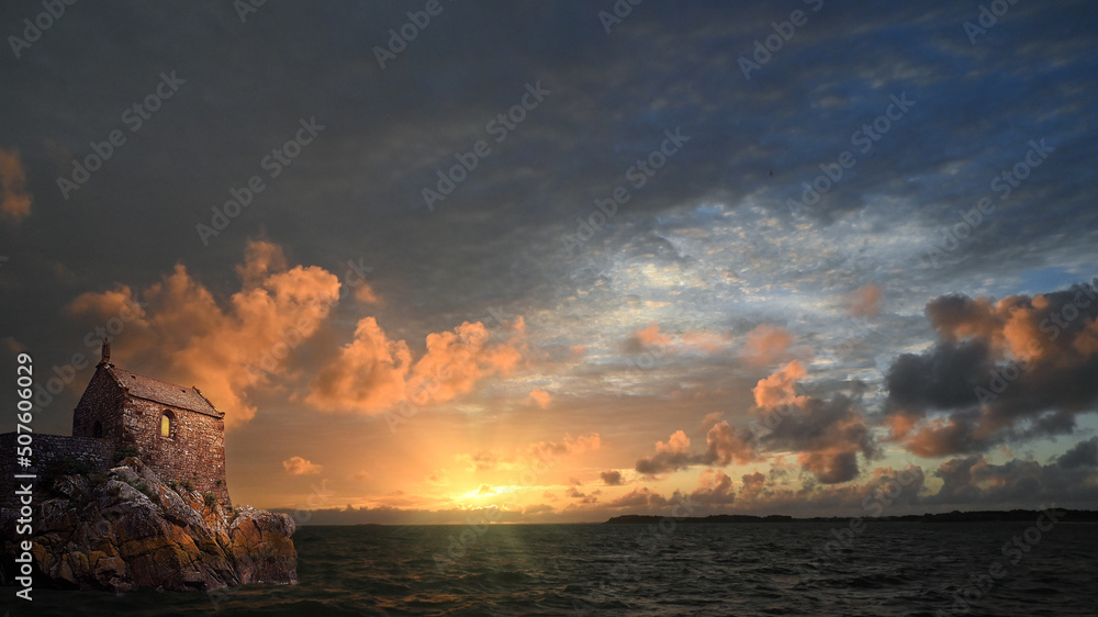 Old chapel on french atlantic coast by sunrise with cloudscape