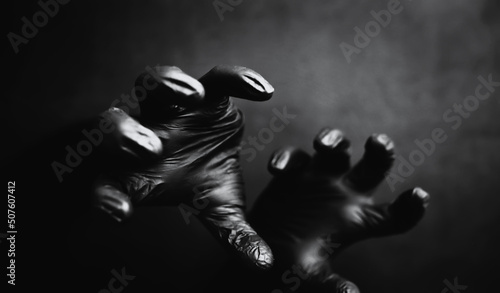 Background of hands in black gloves. Horror and hand monsters. Black hand gestures. © alexkich