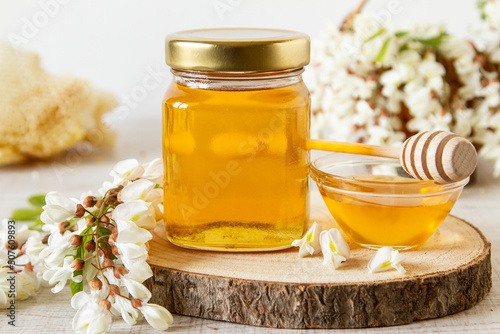  Acacia honey in a jar. Leaves and flowers of acacia tree. Freshly acacia honey.