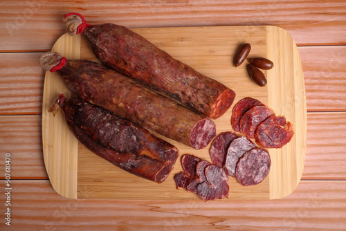 Iberian sausage, Iberian chorizo and Iberian tenderloin on cutting board and wooden table.