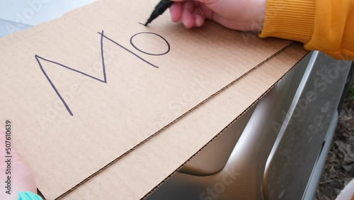 woman writes with marker on cardboard monkeypox photo