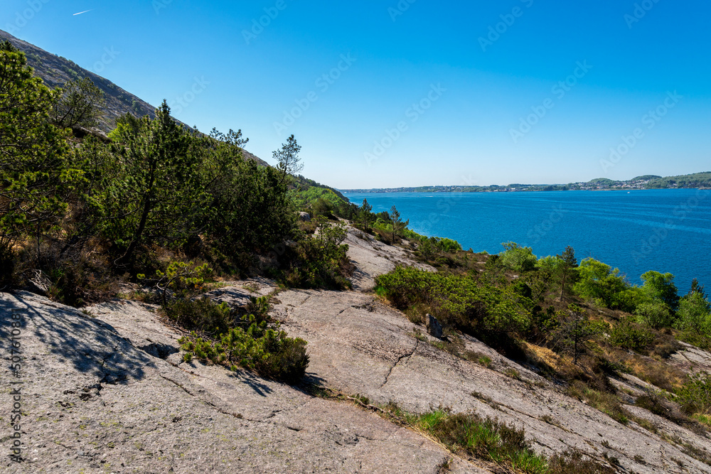 A rocky slope of Lifjel with trees and bushes and view to the fjord, Sandnes, Norway, May 2018