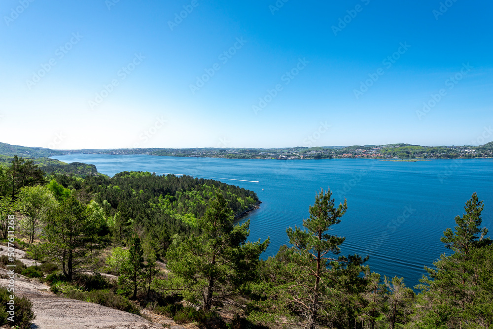 A spectacular view clear blue waters of Gandsfjord fjord and Stavanger suburbs coastline while hiking to Lifjel mountain, Norway, May 2018