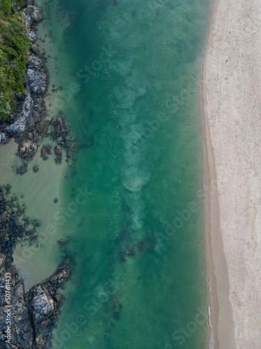 Downward aerial view of beach and crystal clear water