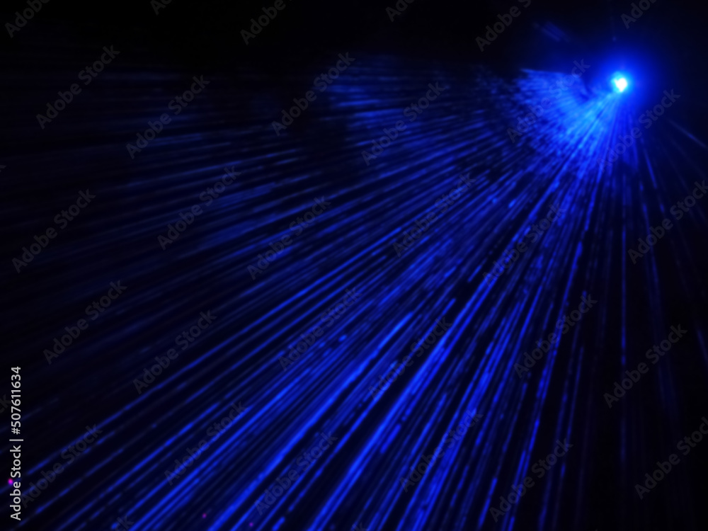 Fototapeta premium Outdoor projector shines bright neon blue beams in the dark. Laser show. Blurred image
