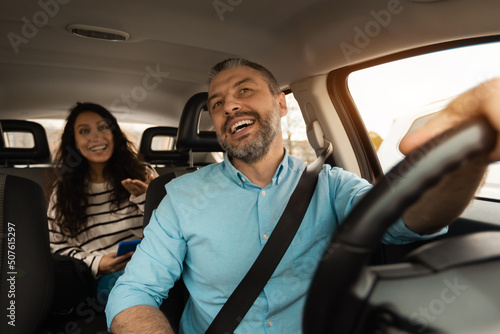 Portrait of happy male driver riding car with passenger