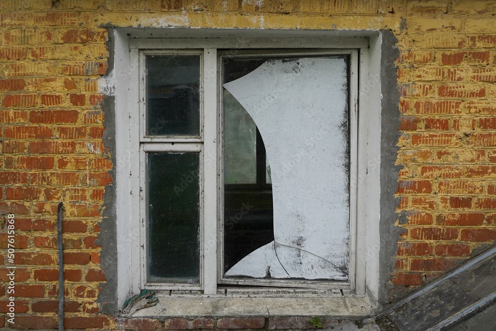 Broken glass window with brick wall background
