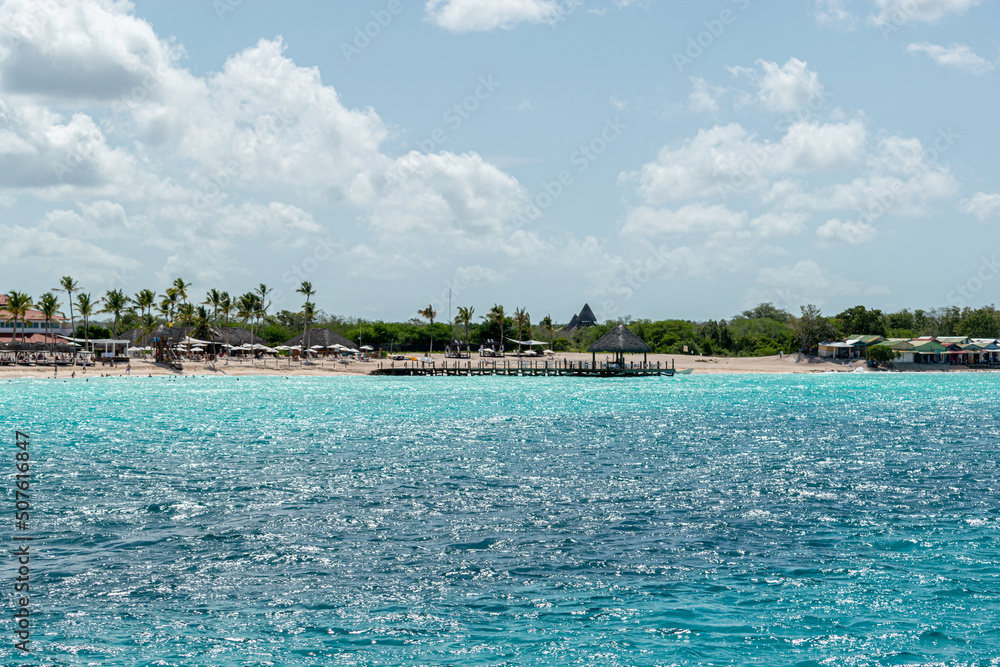 island surrounded by turquoise waters photographed from a boat