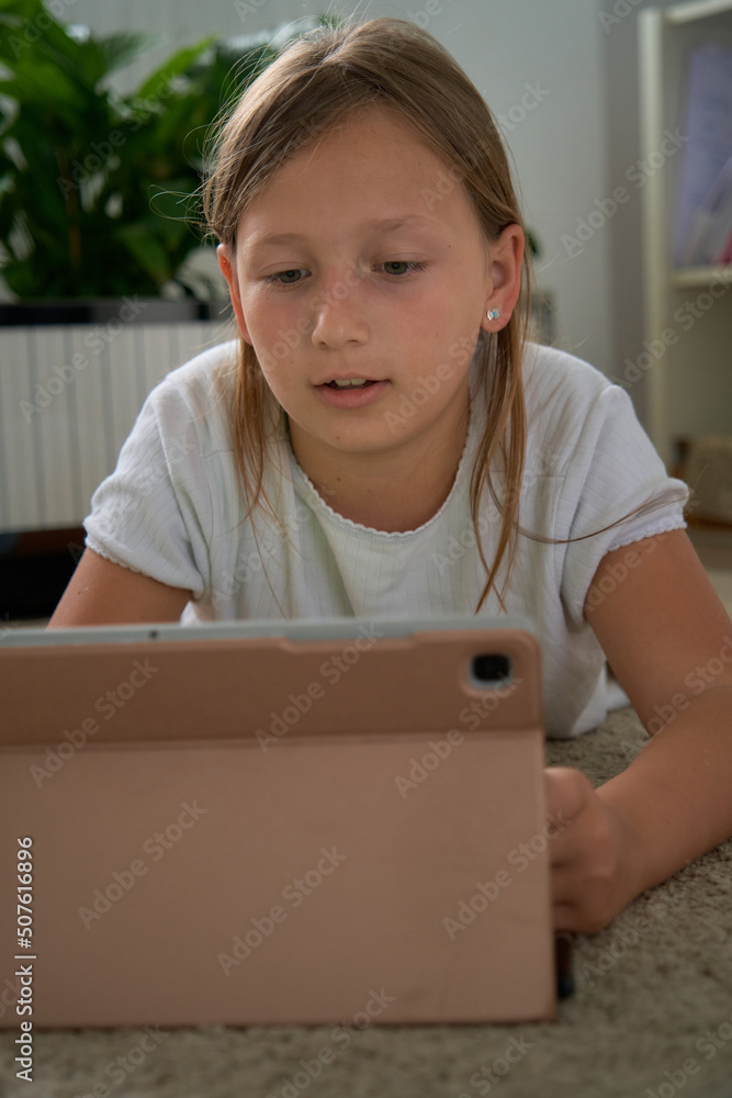 a girl does her homework on a tablet a girl does her homework on a tablet