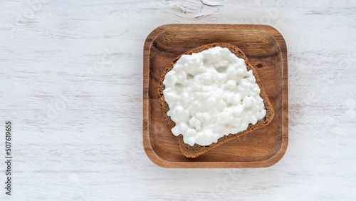 Sandwich with cottage cheese on wooden background.