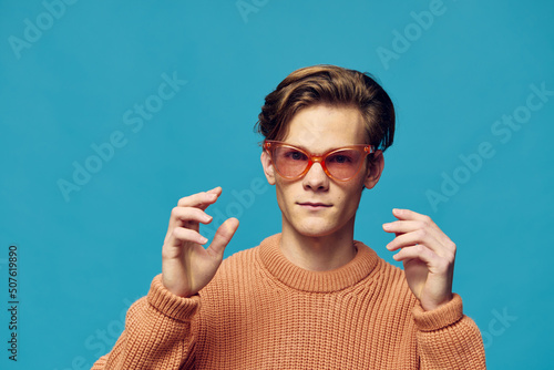 portrait of a funny young man in pink female glasses