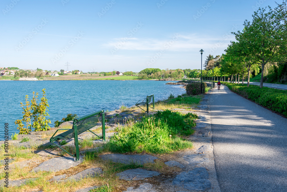 Benches along a footpath at Hafrsfjord bay coast near the Sword in Rock monument, Stavanger, Norway, May 2018
