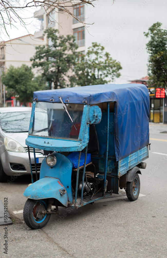 Tuk tuk - traditional indian moto rickshaw taxi on one of the street. passenger cars.