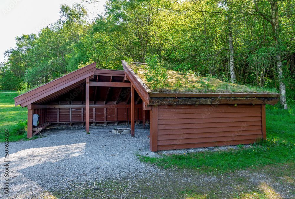 A roof covered shelter hut with a campfire circle in the middle in Halandsvatnet lake park, Stavanger, Norway, May 2018